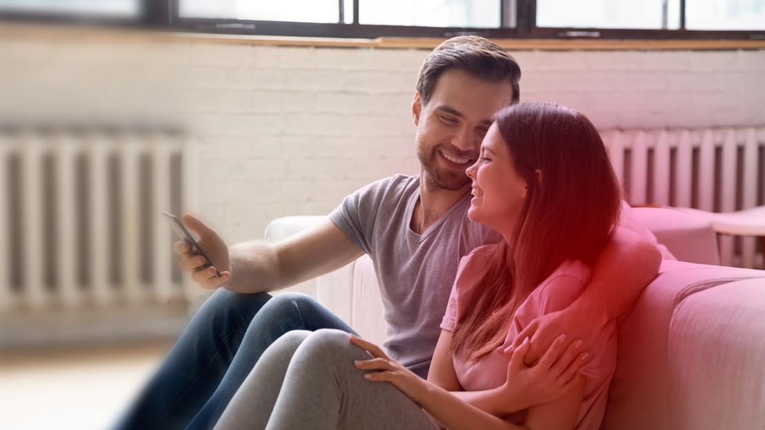 Gas Stadtwerke Ostmünsterland - Ein Mann und eine Frau sitzen gemütlich im warmen Wohnzimmer Gas Stadtwerke Ostmünsterland - Ein Mann und eine Frau sitzen gemütlich im warmen Wohnzimmer