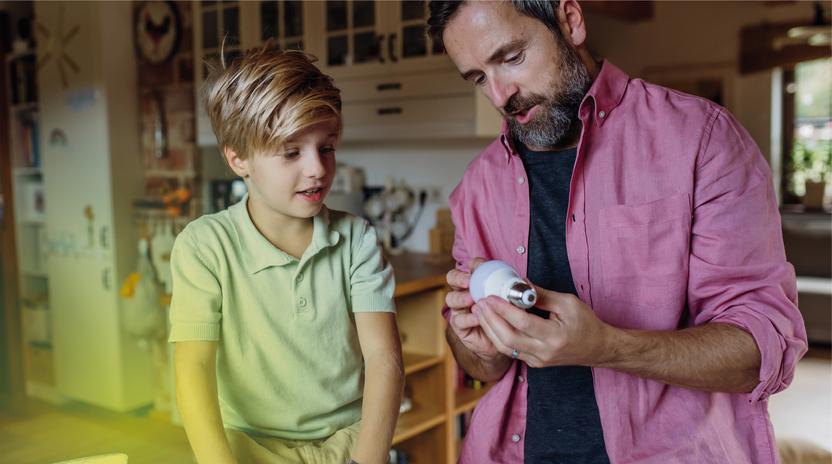 Strom Stadtwerke Ostmünsterland - Vater und Sohn mit einer LED-Leuchte