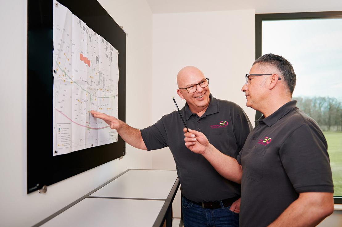 Zwei Meister schauen einen Netzplan an Zwei Meister schauen einen Netzplan an