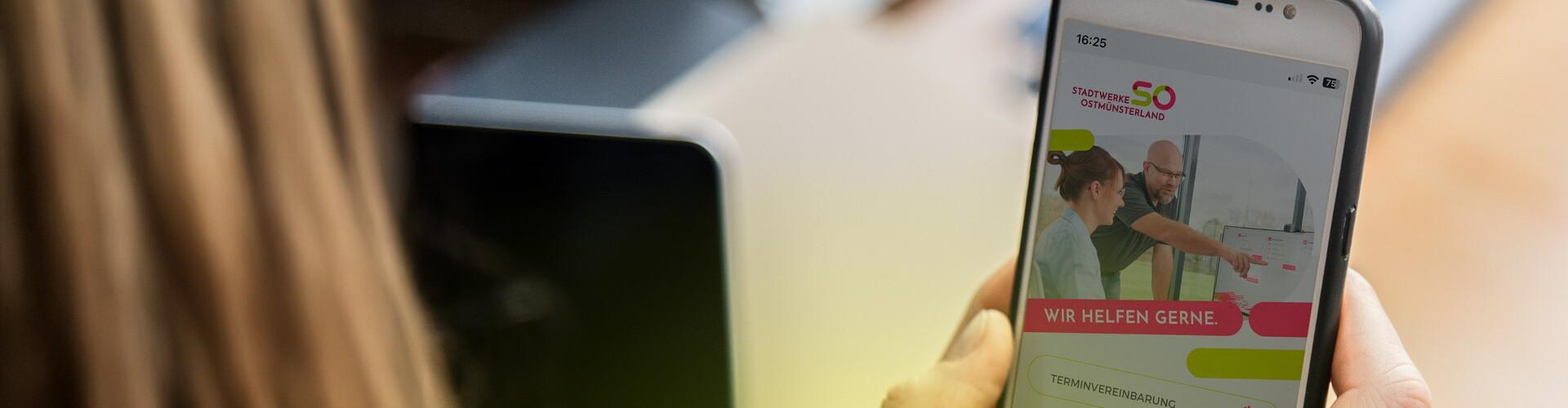 Zwei H&auml;nde halten ein Smartphone mit der App Mein.SO auf dem Display