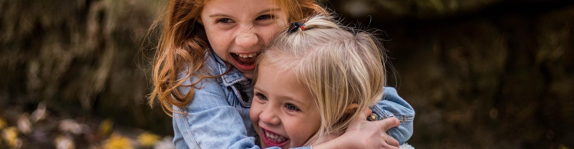 Zwei Mädchen umarmen sich herzlich im Wald