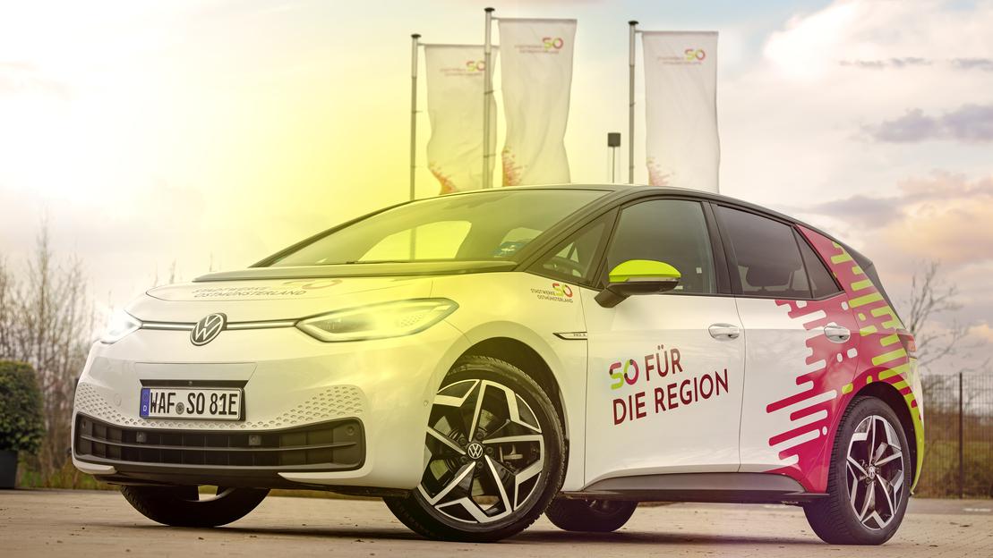 Ein weißes E-Auto der Stadtwerke Ostmünsterland auf einem Parkplatz