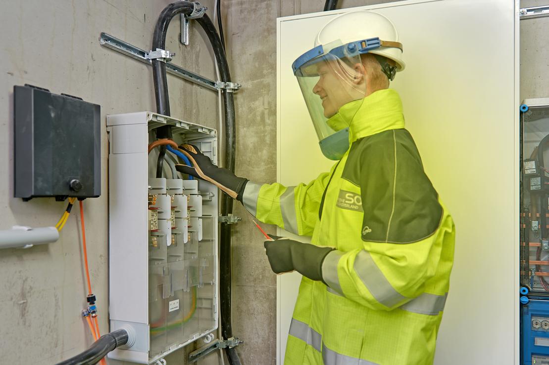 Ein Elektriker arbeitet in Schutzkleidung am Hausanschluss Ein Elektriker arbeitet in Schutzkleidung am Hausanschluss