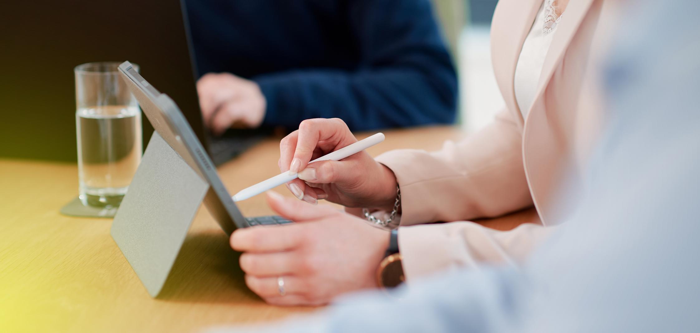 Eine Frau tippt mit einem Stift auf einem Tablet