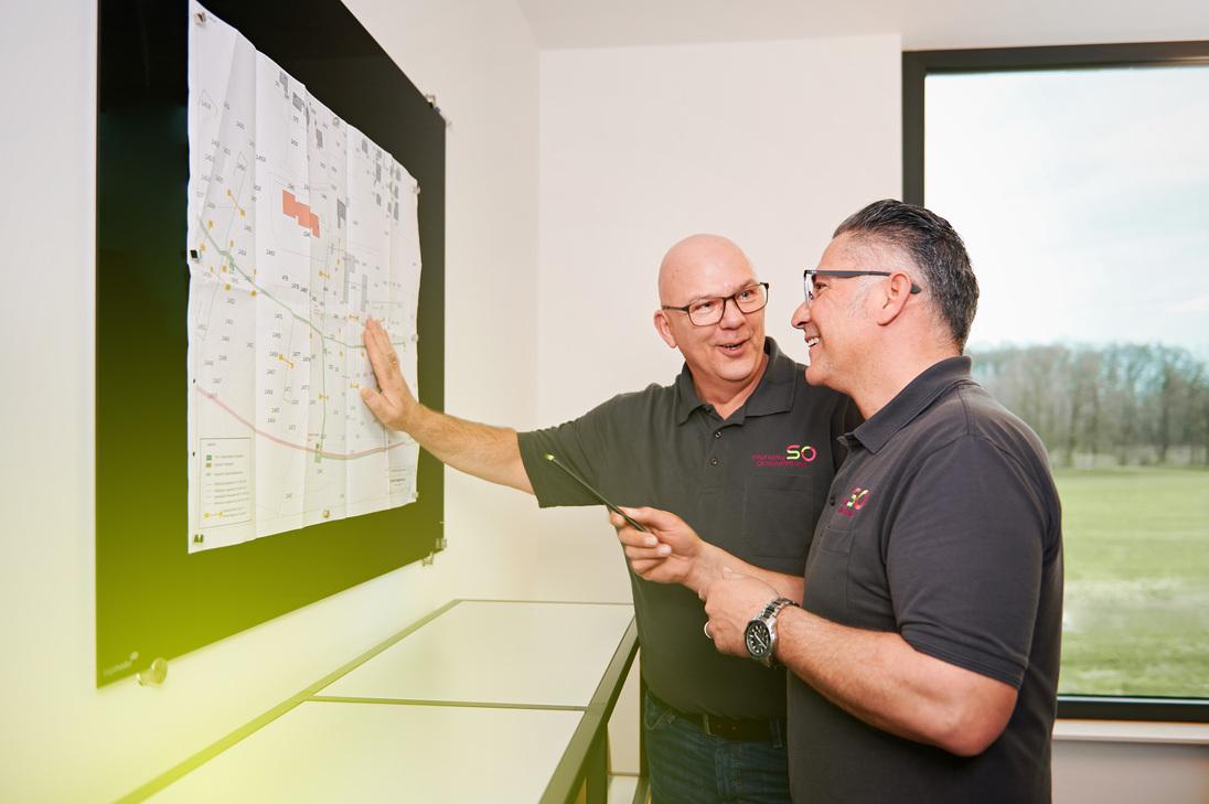 Zwei Techniker der Stadtwerke Ostmünsterland schauen auf einen Leitungsplan Zwei Techniker der Stadtwerke Ostmünsterland schauen auf einen Leitungsplan