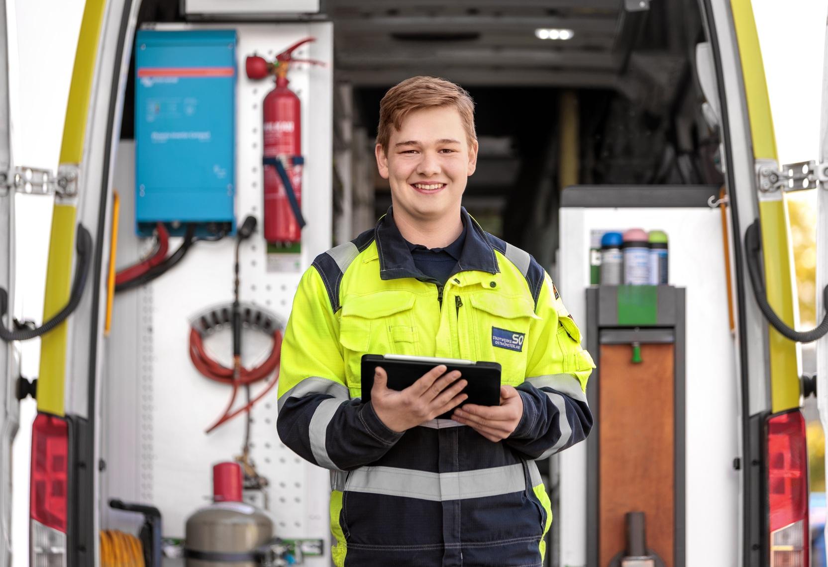 Ein Mitarbeiter der Stadtwerke Ostmünsterland steht mit einem Tablet vor einem geöffneten Servicefahrzeug und nutzt digitale Technik für die Einsatzdokumentation Ein Mitarbeiter der Stadtwerke Ostmünsterland steht mit einem Tablet vor einem geöffneten Servicefahrzeug und nutzt digitale Technik für die Einsatzdokumentation
