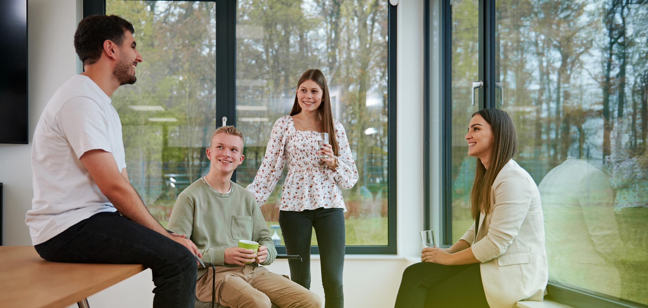 Vier Azubis der Stadtwerke Ostmünsterland sitzen entspannt zusammen