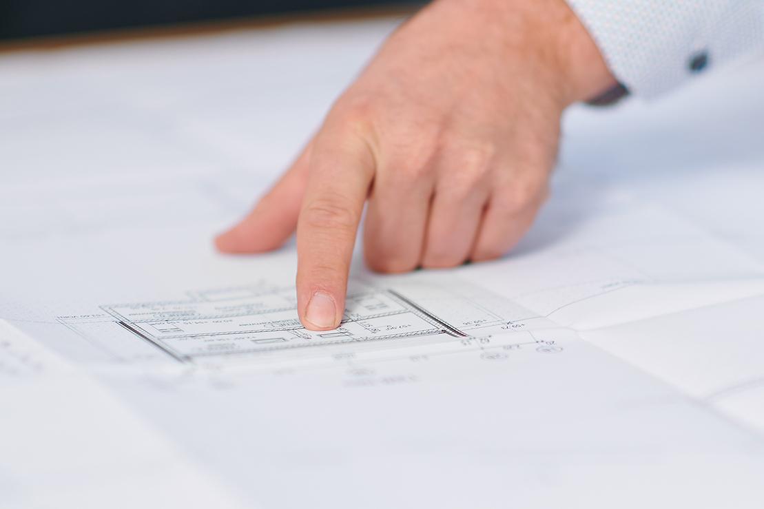 Ein Finger zeigt auf einen technischen Plan