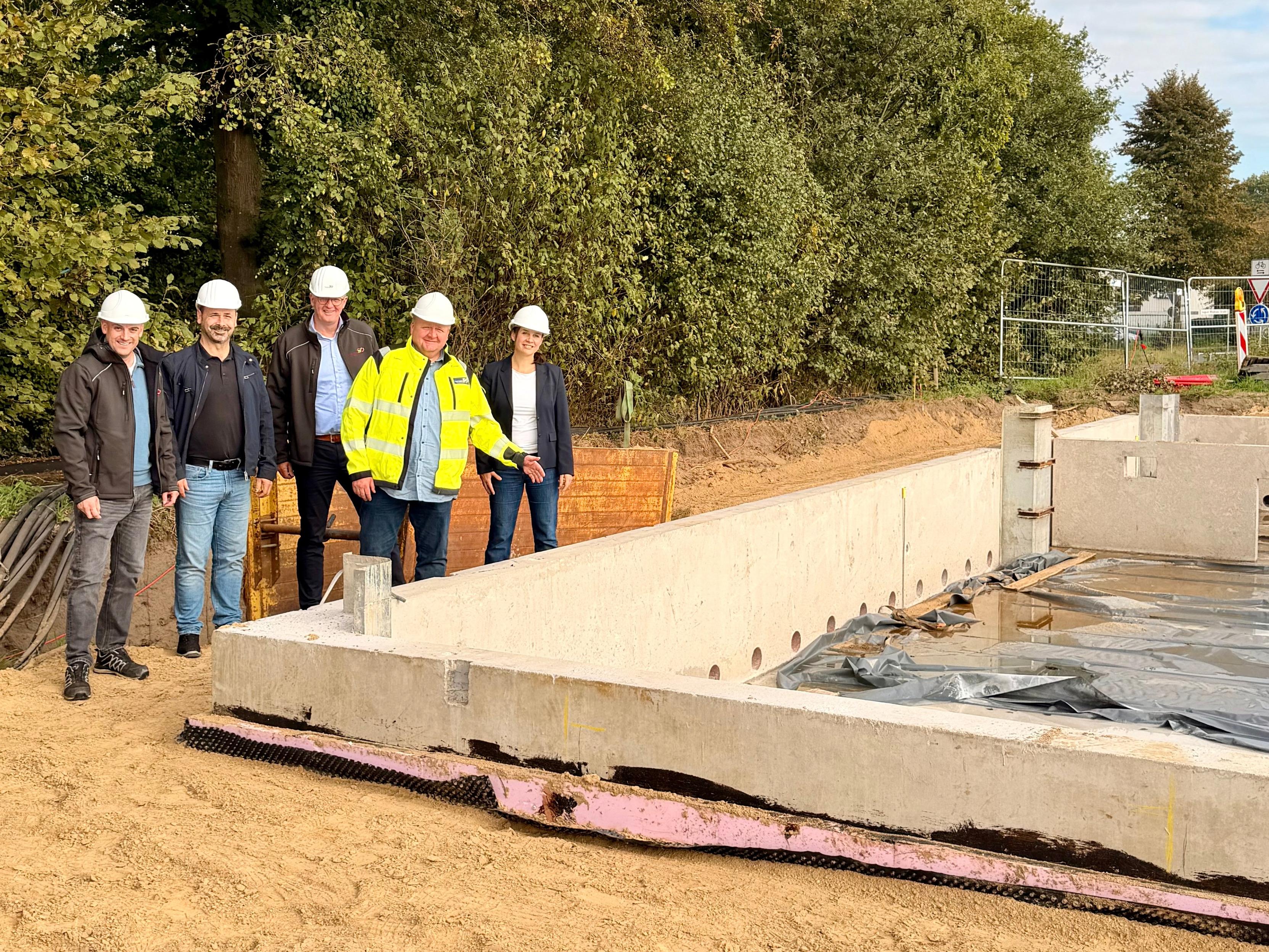 Pressefoto mit Mitarbeitenden der Stadtwerke Ostm&uuml;nsterland vor dem Rohbau des neuen Schalthauses Telgte