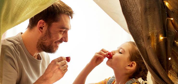 Ein Mann und ein Mädchen sitzen in einem Spielzelt