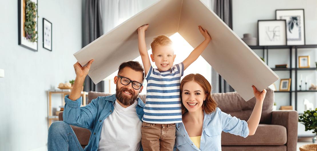 Familie mit kleinem Kind unter einem Pappdach