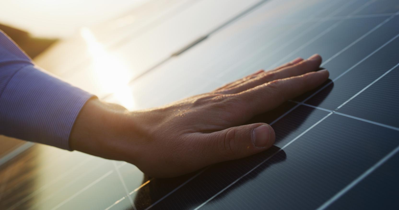 Eine Hand auf einem PV-Modul Eine Hand auf einem PV-Modul