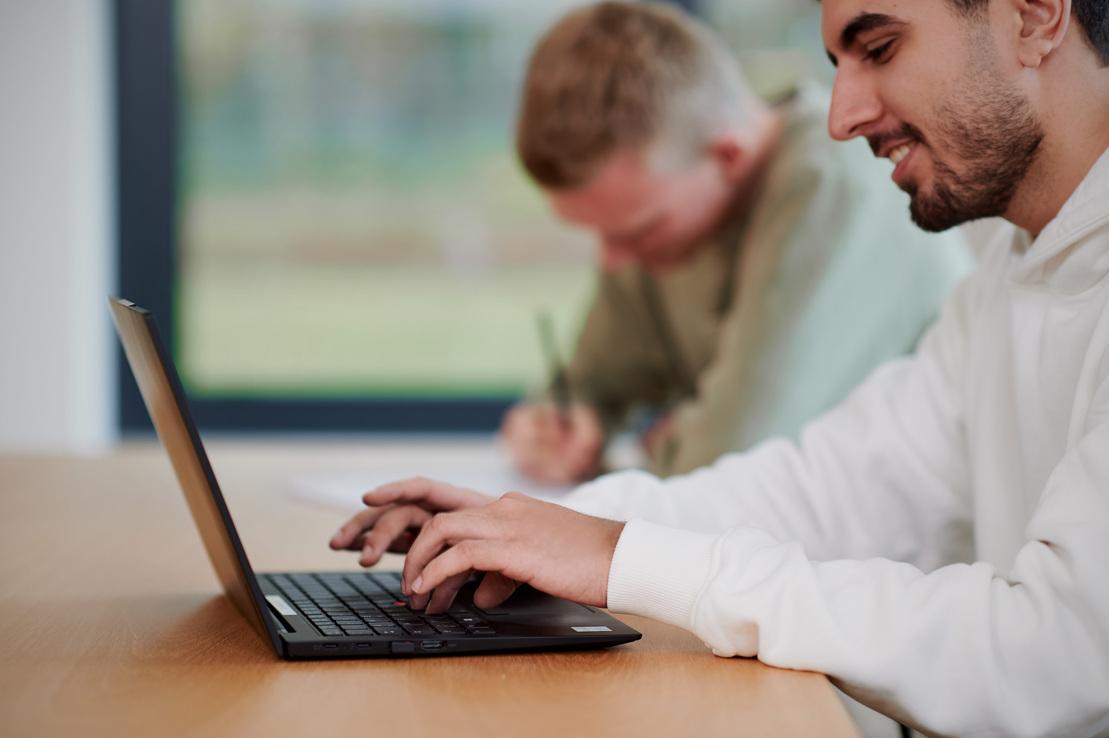 Ein junger Mann sitzt am Laptop