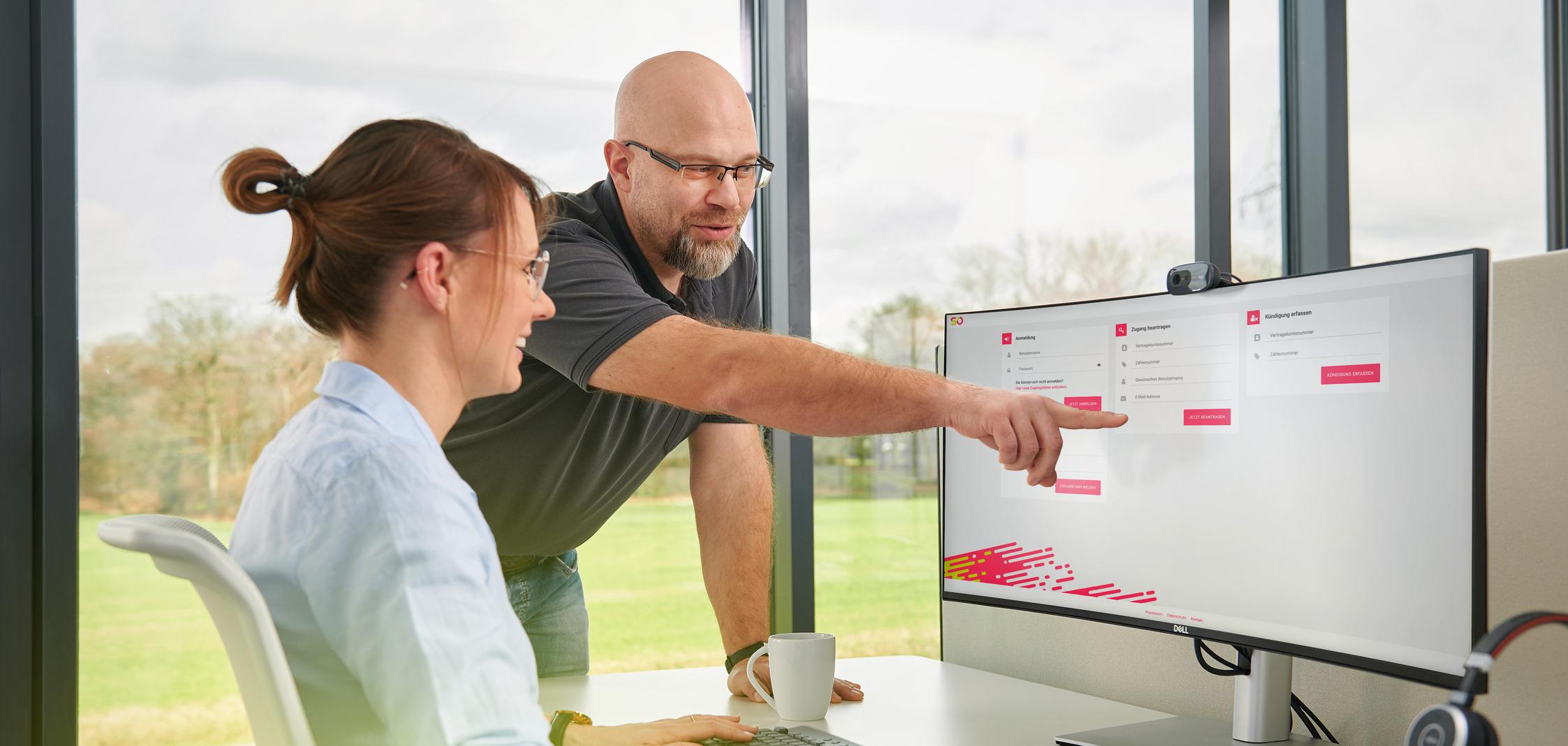 Eine Frau und ein Mann besprechen sich am Schreibtisch